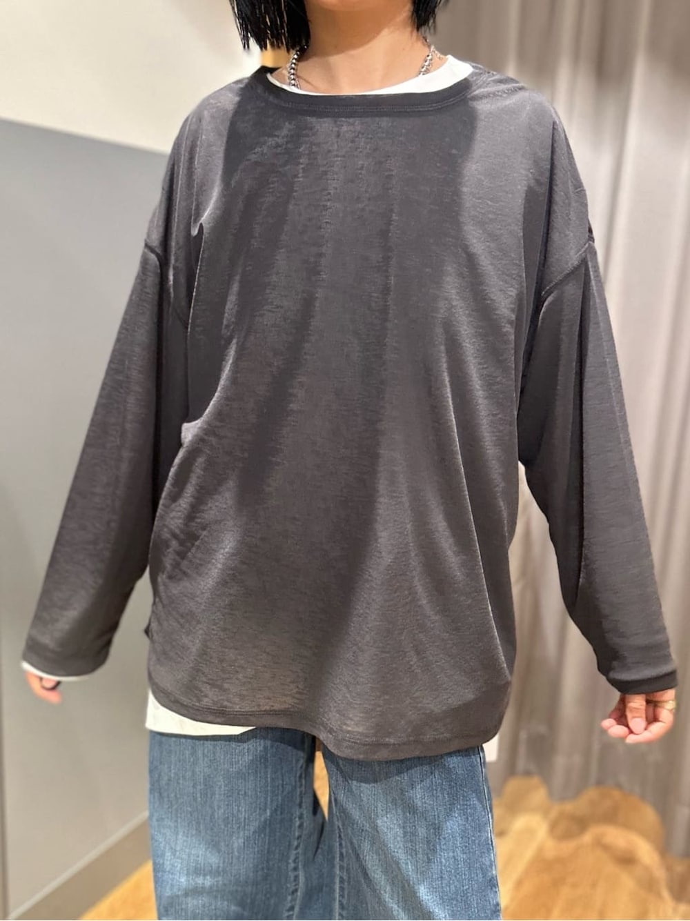 グレー系のTシャツ/カットソー、ブラック系のベスト、ブルー系のデニムパンツを着用したレディースの春コーディネートの7枚目の写真
