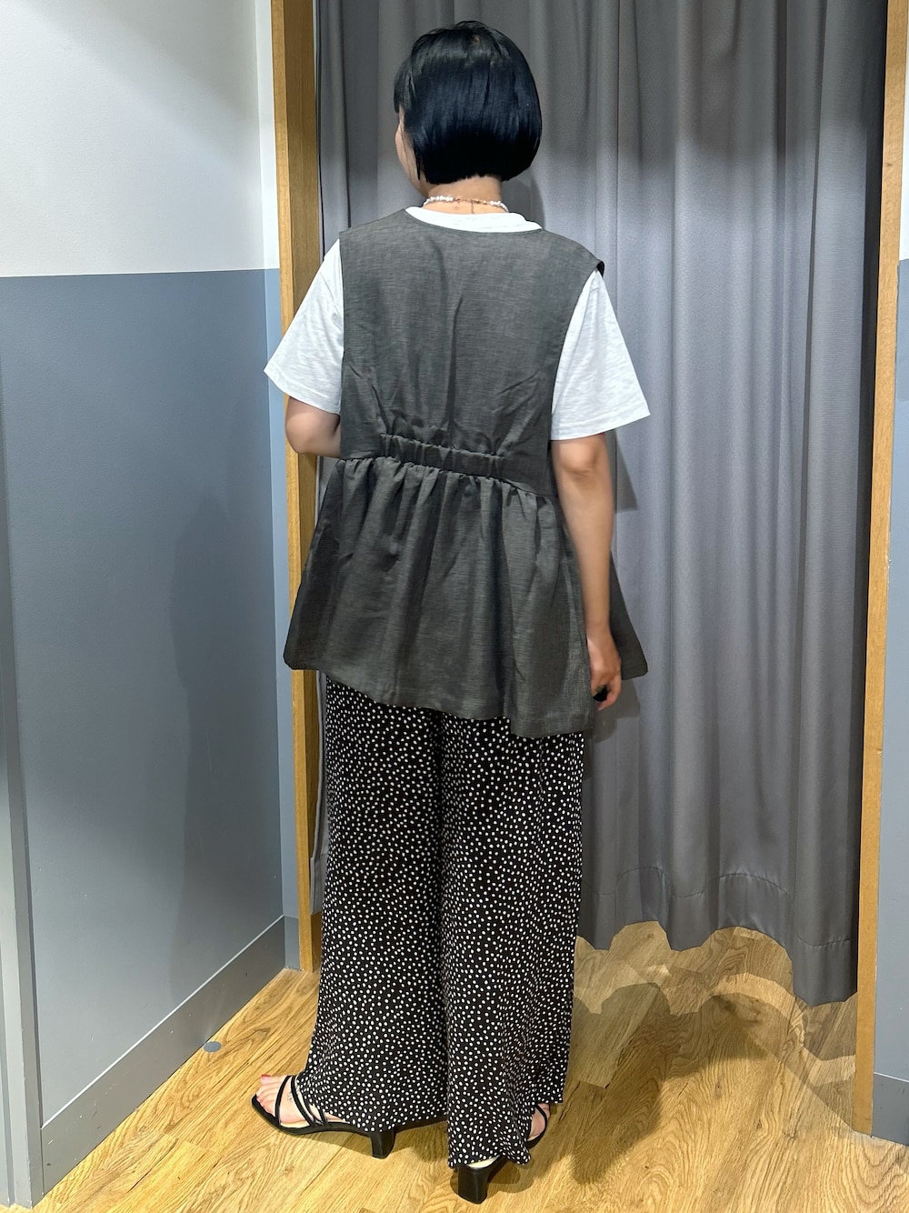 ホワイト系のその他パンツ、グレー系のベスト、ブラック系のショルダーバッグを着用したレディースの夏コーディネートの3枚目の写真