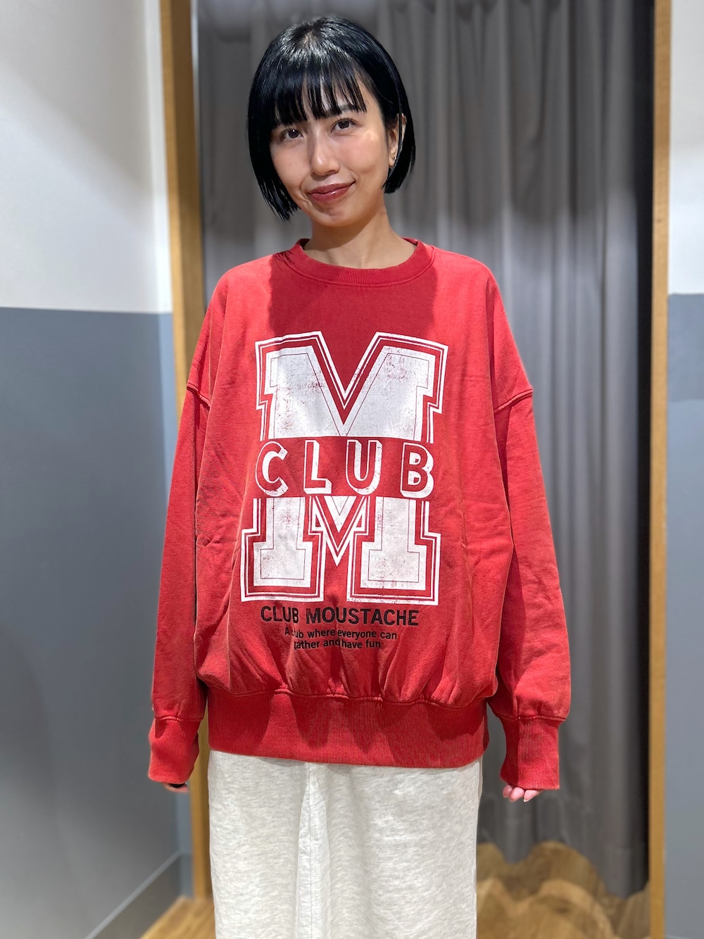 レッド系のスウェット、グレー系のスカート、ブルー系のシャツ/ブラウスを着用したレディースの秋コーディネートの6枚目の写真