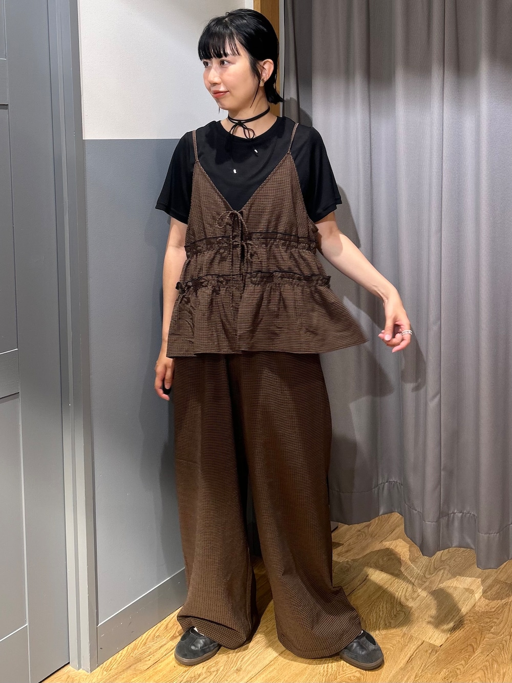ブラウン系のセットアップ、ブラック系のTシャツ/カットソー、ブラック系のショルダーバッグを着用したレディースの夏コーディネートの2枚目の写真
