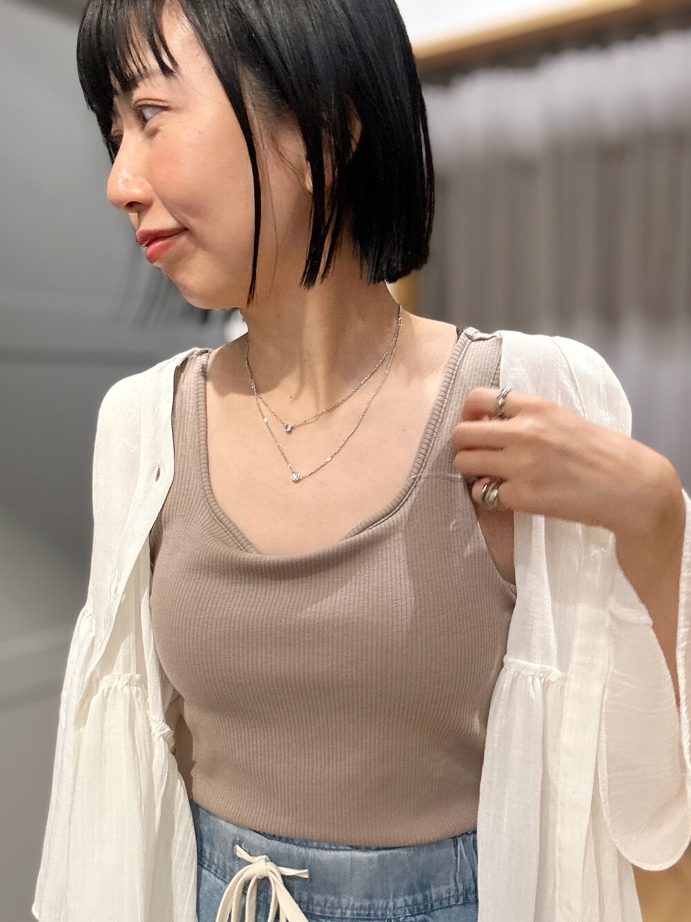 ベージュ系のタンクトップ、ホワイト系のシャツ/ブラウス、ブルー系のデニムパンツを着用したレディースの夏コーディネートの6枚目の写真