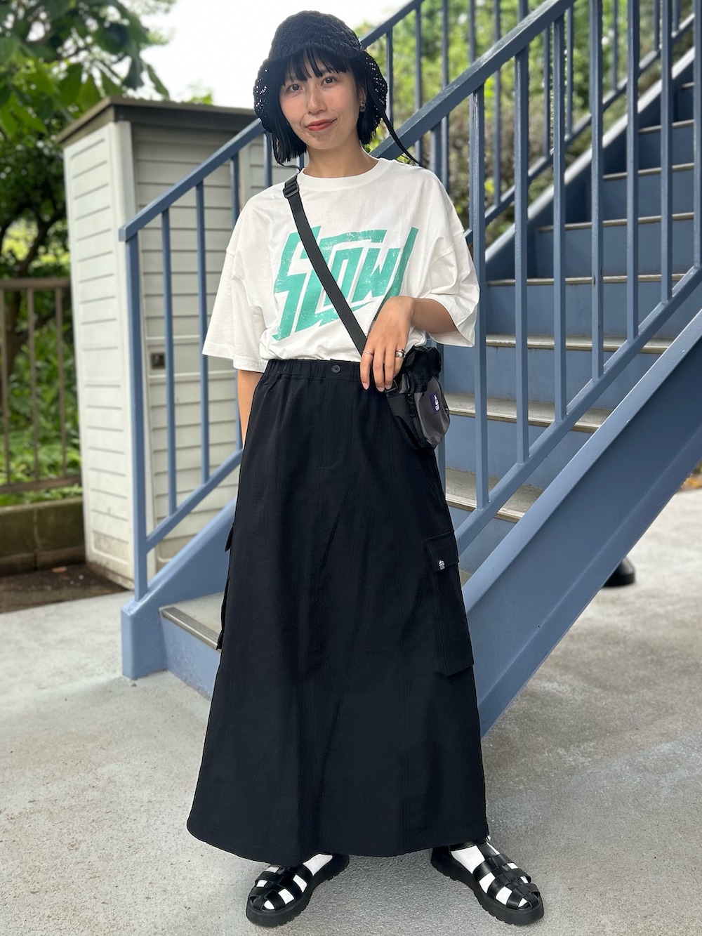 ホワイト系のTシャツ/カットソー、ブラック系のスカート、ブラック系のハットを着用したレディースの春コーディネートの2枚目の写真