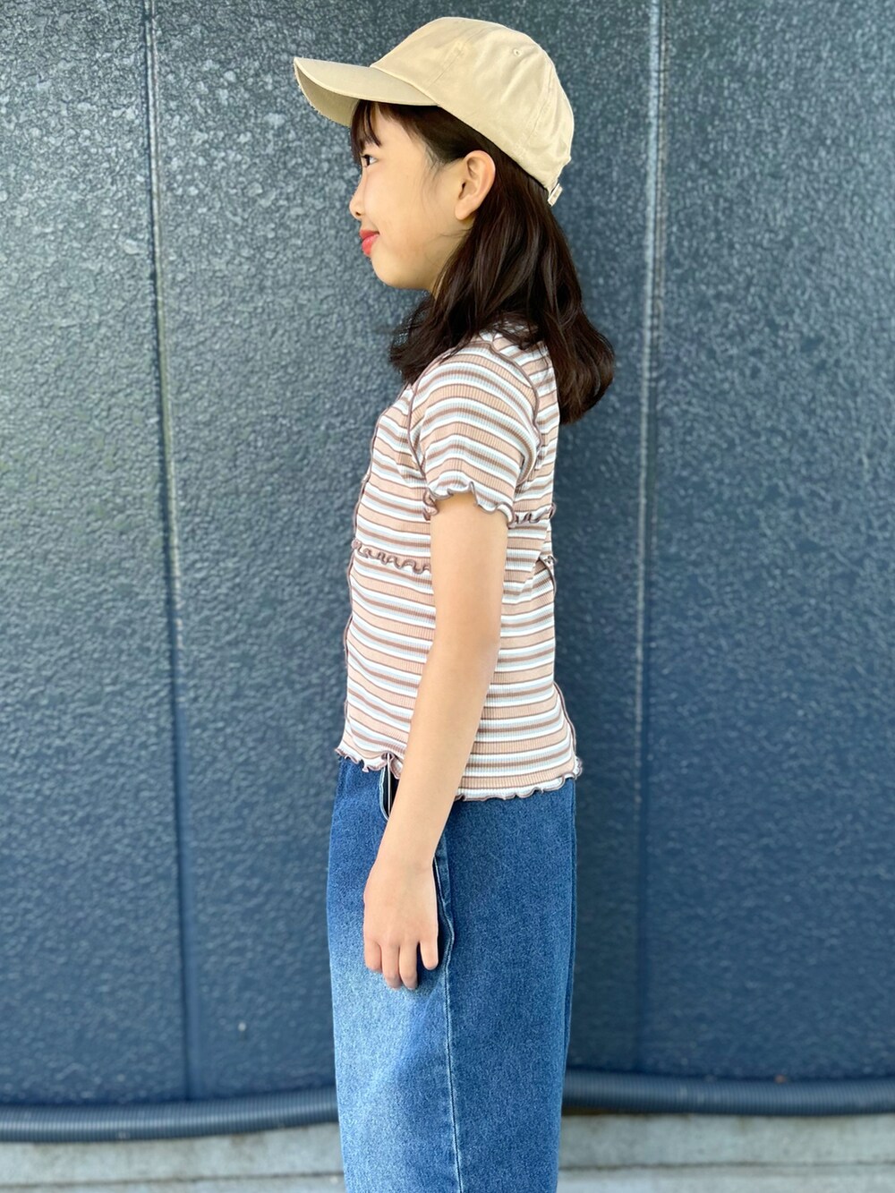 ブルー系のデニムパンツ、ブラウン系のTシャツ/カットソー、ベージュ系のキャップを着用したキッズの夏コーディネートの5枚目の写真