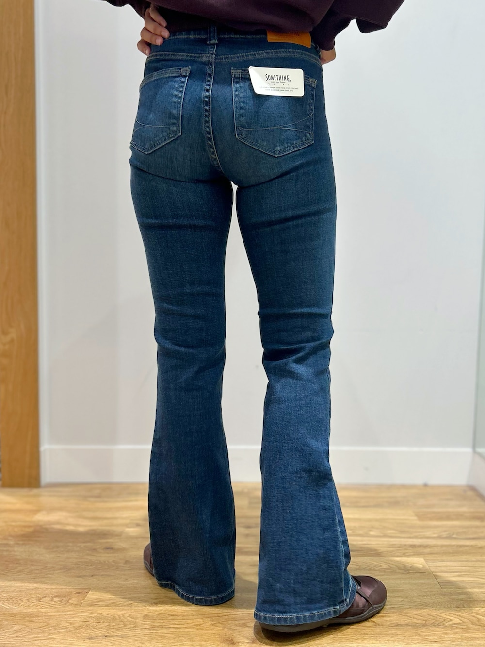 レッド系のスウェット、ブルー系のその他パンツ、ブラック系のショルダーバッグを着用したレディースの秋コーディネートの8枚目の写真