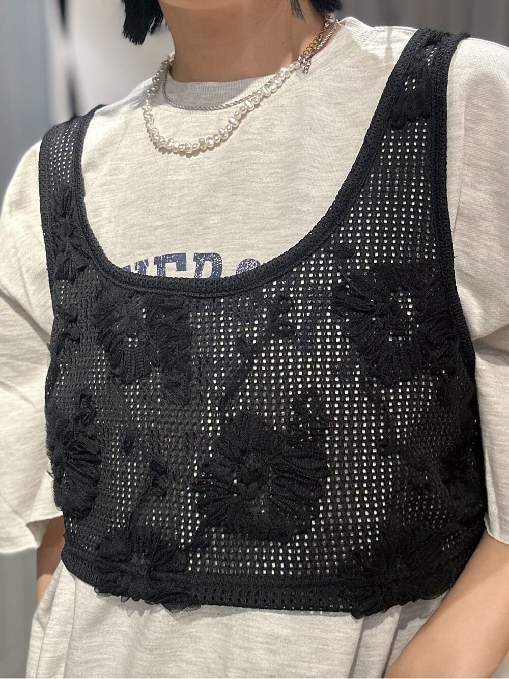 ホワイト系のTシャツ/カットソー、ブラック系のベスト、ブラック系のその他パンツを着用したレディースの春コーディネートの5枚目の写真