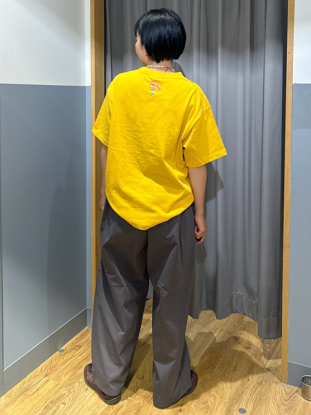 イエロー系のTシャツ/カットソー、グレー系のその他パンツ、ベージュ系のトートバッグを着用したレディースの夏コーディネートの3枚目の写真