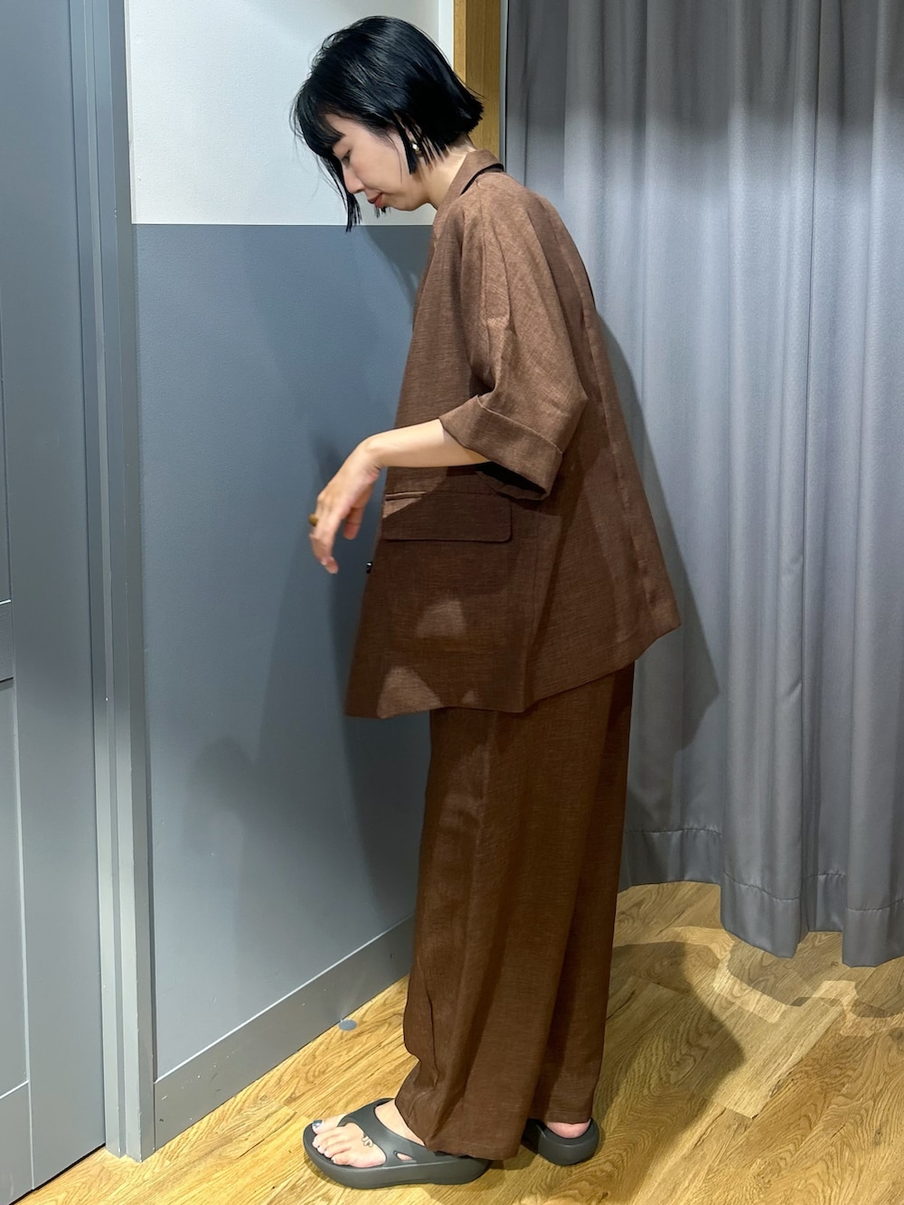 ブラウン系のテーラードジャケット、ブラウン系のその他パンツ、ホワイト系のタンクトップを着用したレディースの夏コーディネートの2枚目の写真