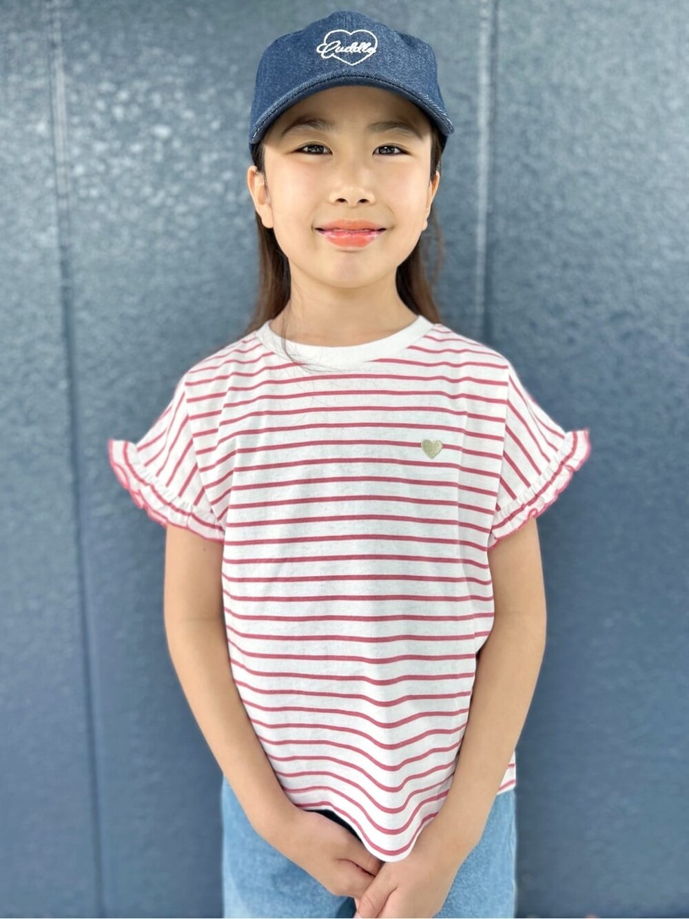 レッド系のTシャツ/カットソー、ブルー系のデニムパンツ、ブルー系のキャップを着用したキッズの春コーディネートの4枚目の写真