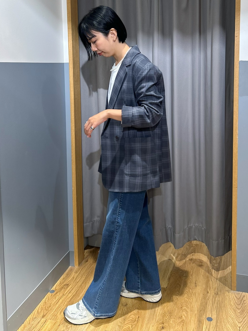 グレー系のテーラードジャケット、グレー系のTシャツ/カットソー、ブルー系のデニムパンツを着用したレディースの秋コーディネートの2枚目の写真