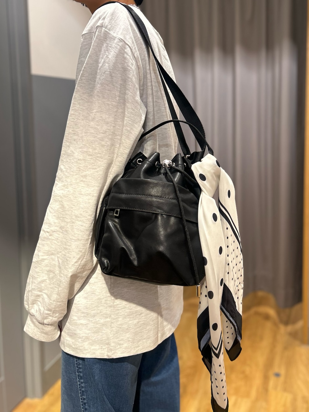グレー系のテーラードジャケット、グレー系のTシャツ/カットソー、ブルー系のデニムパンツを着用したレディースの秋コーディネートの10枚目の写真