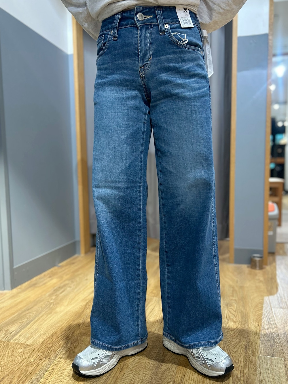 グレー系のテーラードジャケット、グレー系のTシャツ/カットソー、ブルー系のデニムパンツを着用したレディースの秋コーディネートの6枚目の写真