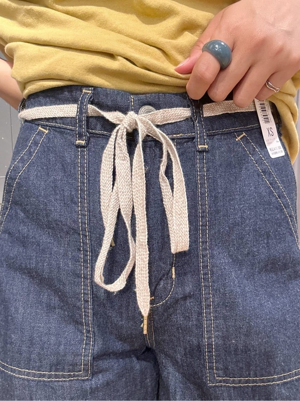 イエロー系のTシャツ/カットソー、ブルー系のデニムパンツ、ブラウン系のバンダナ/スカーフを着用したレディースの夏コーディネートの9枚目の写真
