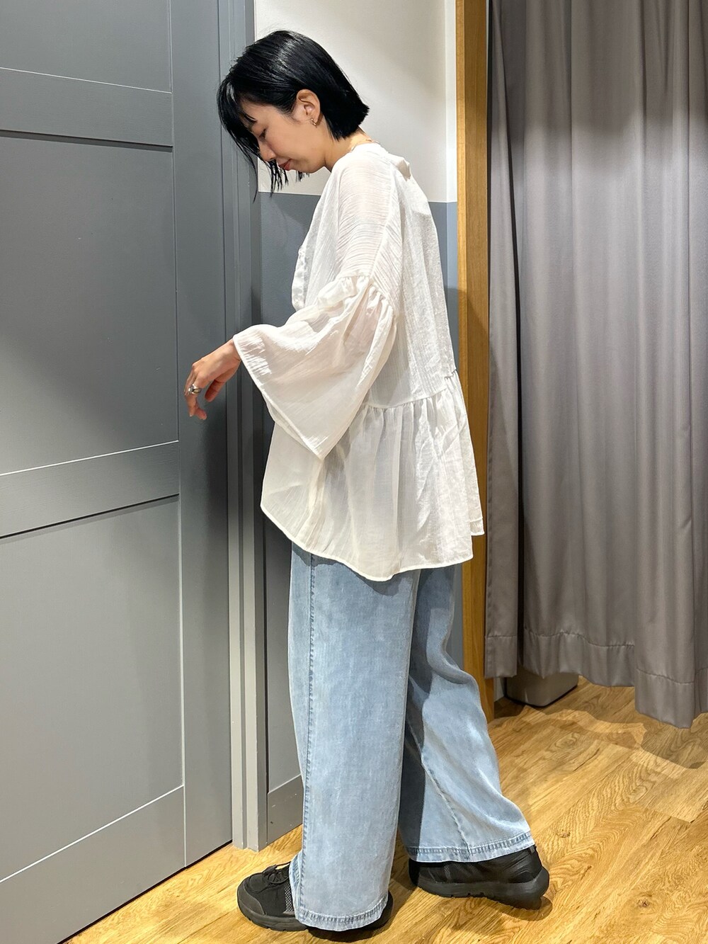 ベージュ系のタンクトップ、ホワイト系のシャツ/ブラウス、ブルー系のデニムパンツを着用したレディースの夏コーディネートの3枚目の写真