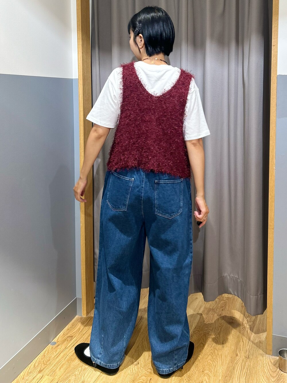 ホワイト系のTシャツ/カットソー、レッド系のベスト、ブルー系のその他パンツを着用したレディースの秋コーディネートの3枚目の写真