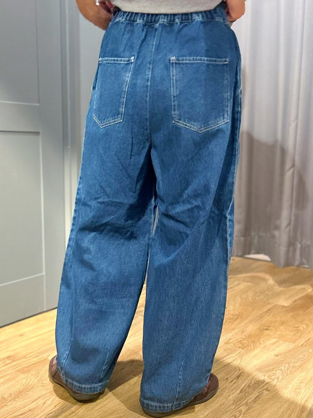 グレー系のその他トップス、グレー系のバックパック/リュック、ブルー系のその他パンツを着用したレディースの夏コーディネートの8枚目の写真