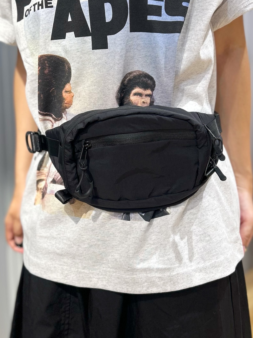 グレー系のTシャツ/カットソー、ブラック系のスカート、ブラック系のボディバッグ/ウエストポーチを着用したレディースの夏コーディネートの7枚目の写真