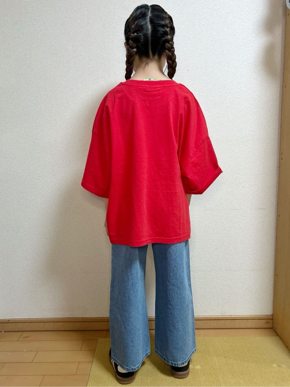 レッド系のTシャツ/カットソー、ブルー系のデニムパンツを着用したキッズの春コーディネートの4枚目の写真