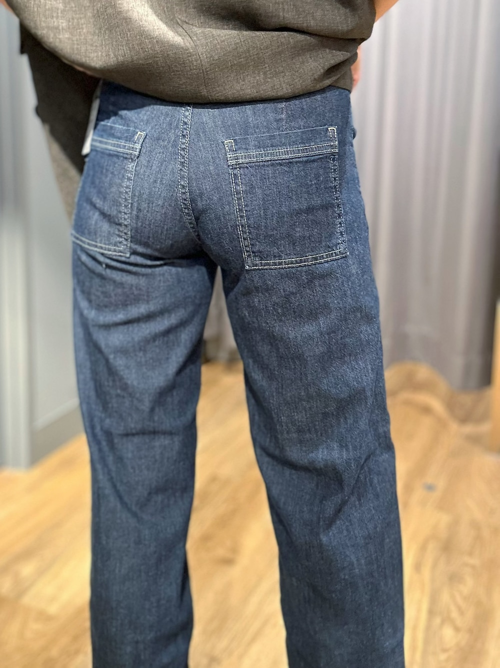 グレー系のテーラードジャケット、ホワイト系のタンクトップ、ブルー系のデニムパンツを着用したレディースの夏コーディネートの7枚目の写真