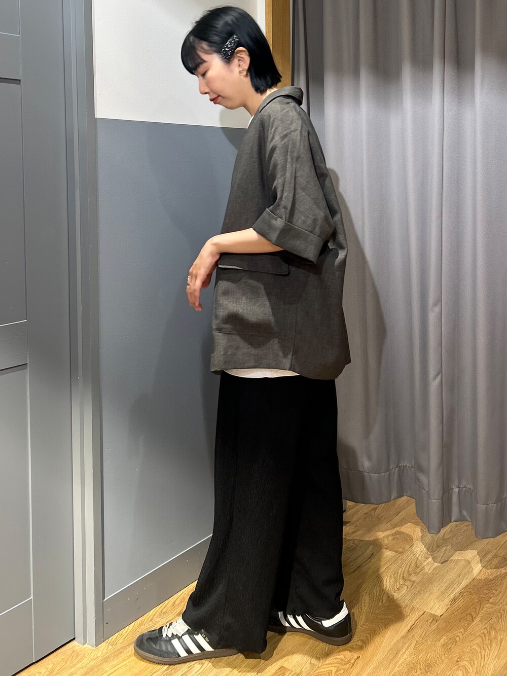 ブラック系のその他パンツ、グレー系のテーラードジャケット、イエロー系のショルダーバッグを着用したレディースの夏コーディネートの3枚目の写真