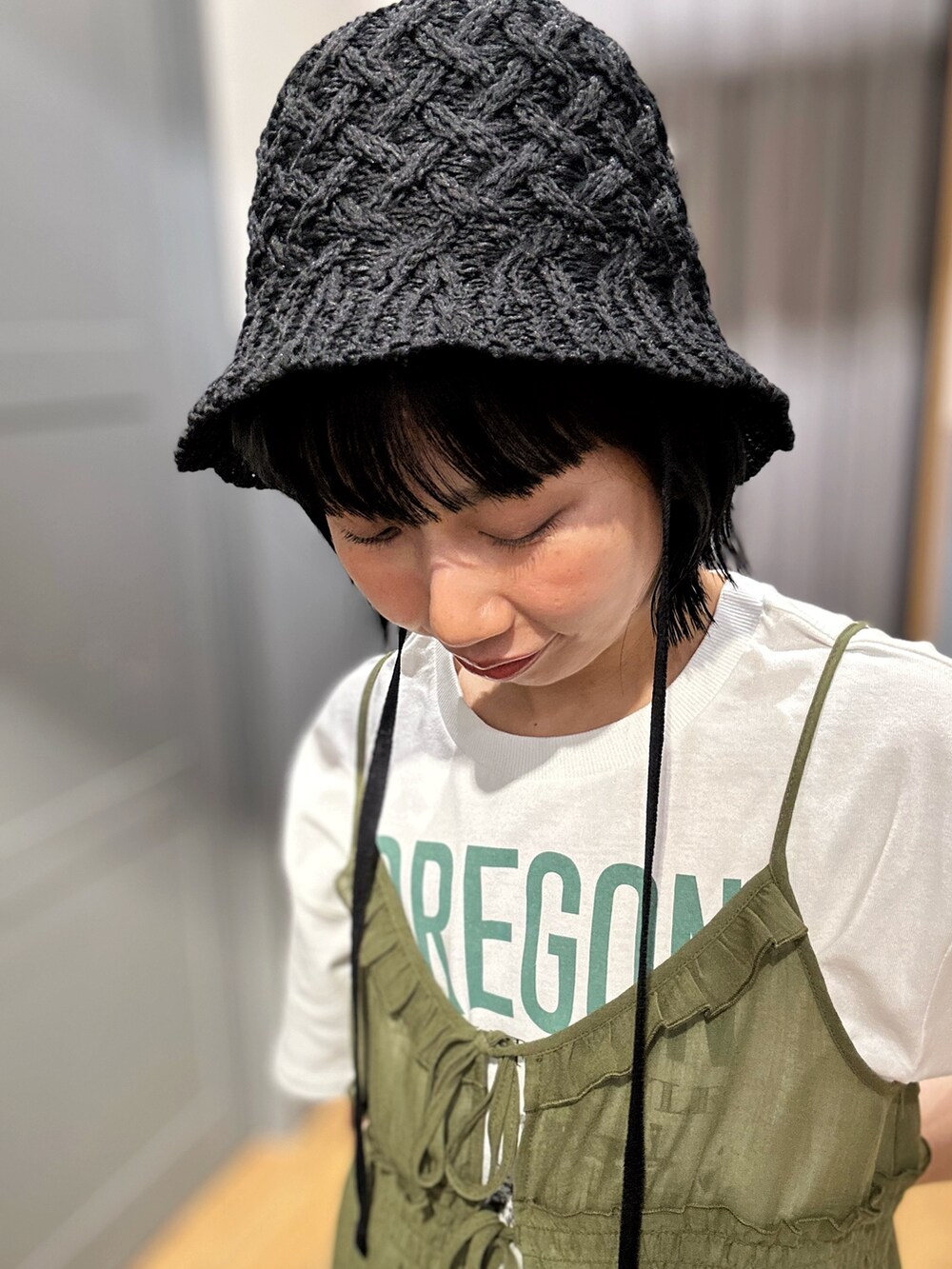 ホワイト系のTシャツ/カットソー、ブラウン系のベスト、ブラック系のハットを着用したレディースの春コーディネートの7枚目の写真