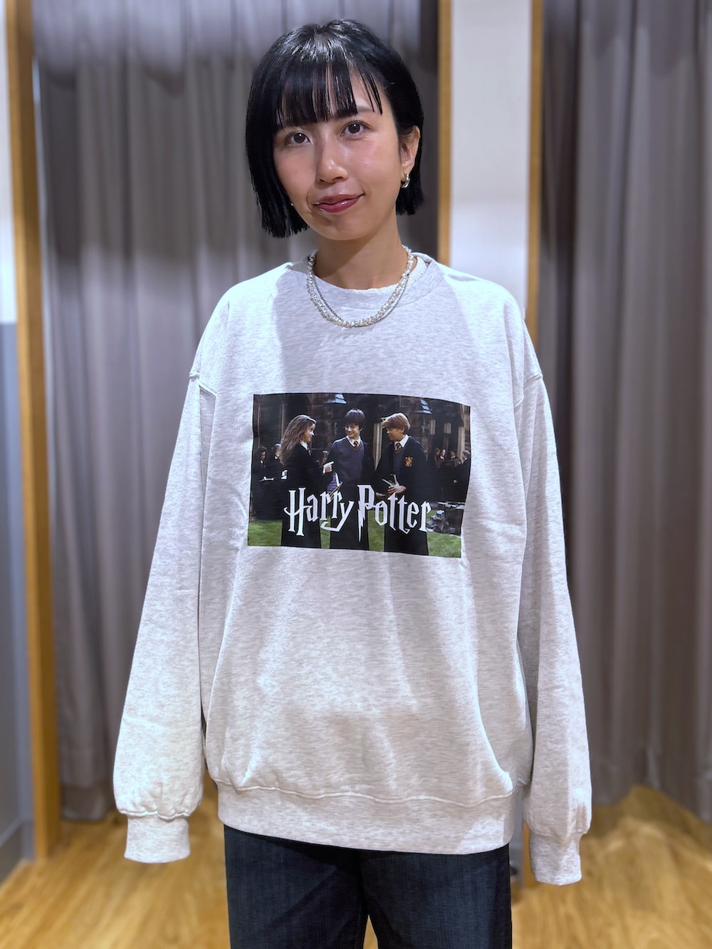ベージュ系のスウェット、ホワイト系のTシャツ/カットソー、ブルー系のデニムパンツを着用したレディースの秋コーディネートの4枚目の写真