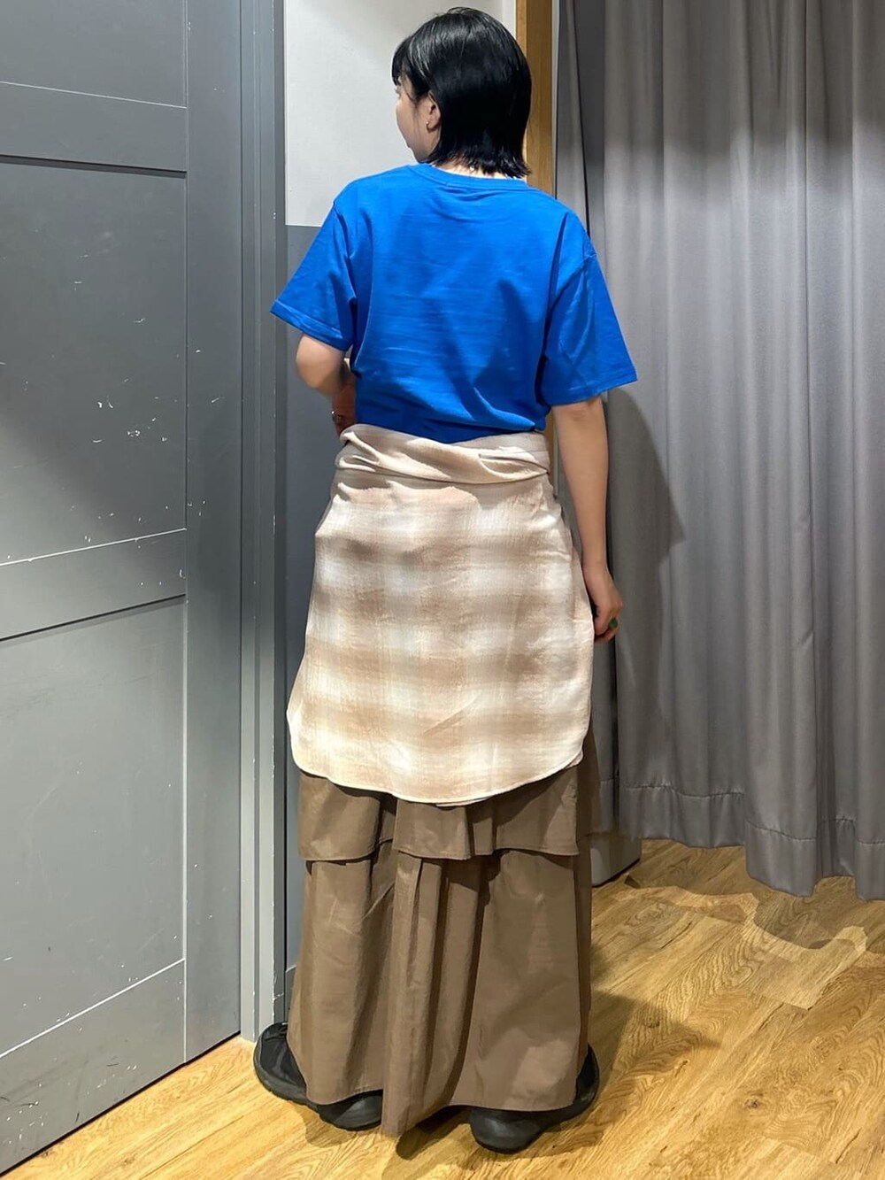 ブルー系のTシャツ/カットソー、ブラウン系のスカート、ベージュ系のシャツ/ブラウスを着用したレディースの春コーディネートの4枚目の写真