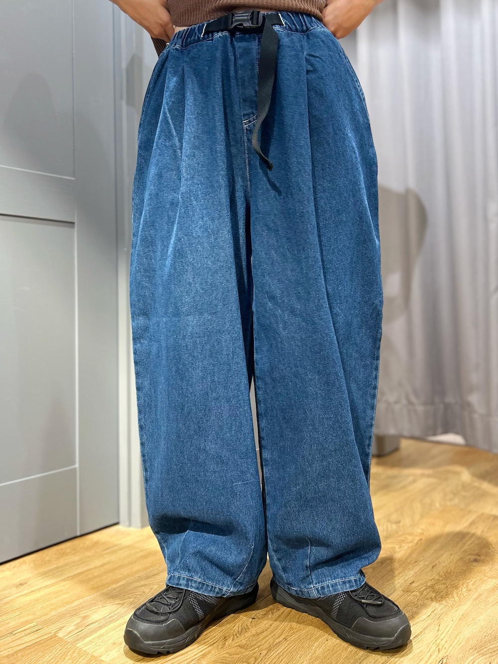 グレー系のニット/セーター、ブルー系のその他パンツ、ベージュ系のショルダーバッグを着用したレディースの夏コーディネートの5枚目の写真