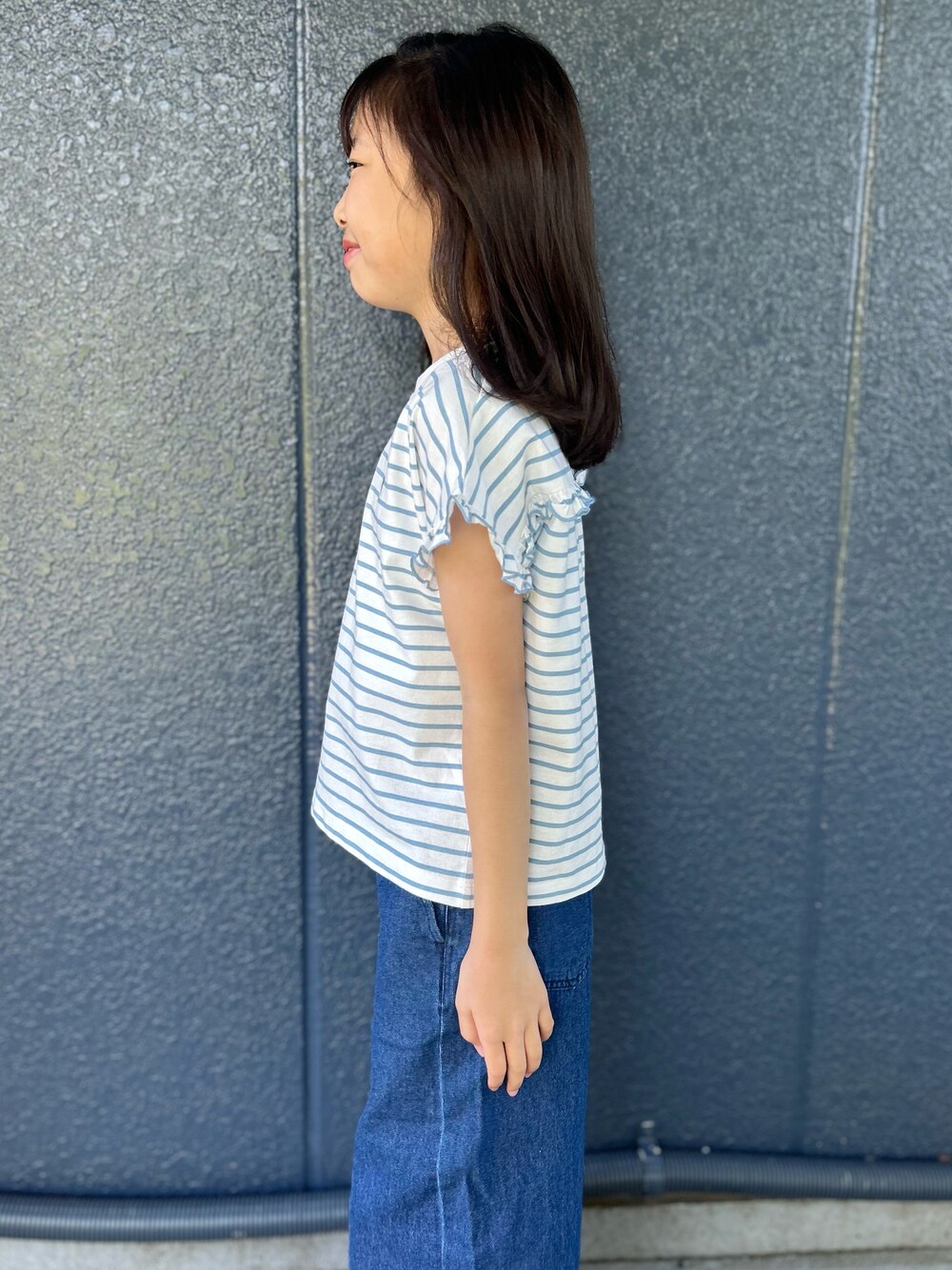 ブルー系のTシャツ/カットソー、ブルー系のデニムパンツ、ブラック系のショルダーバッグを着用したレディースの春コーディネートの4枚目の写真