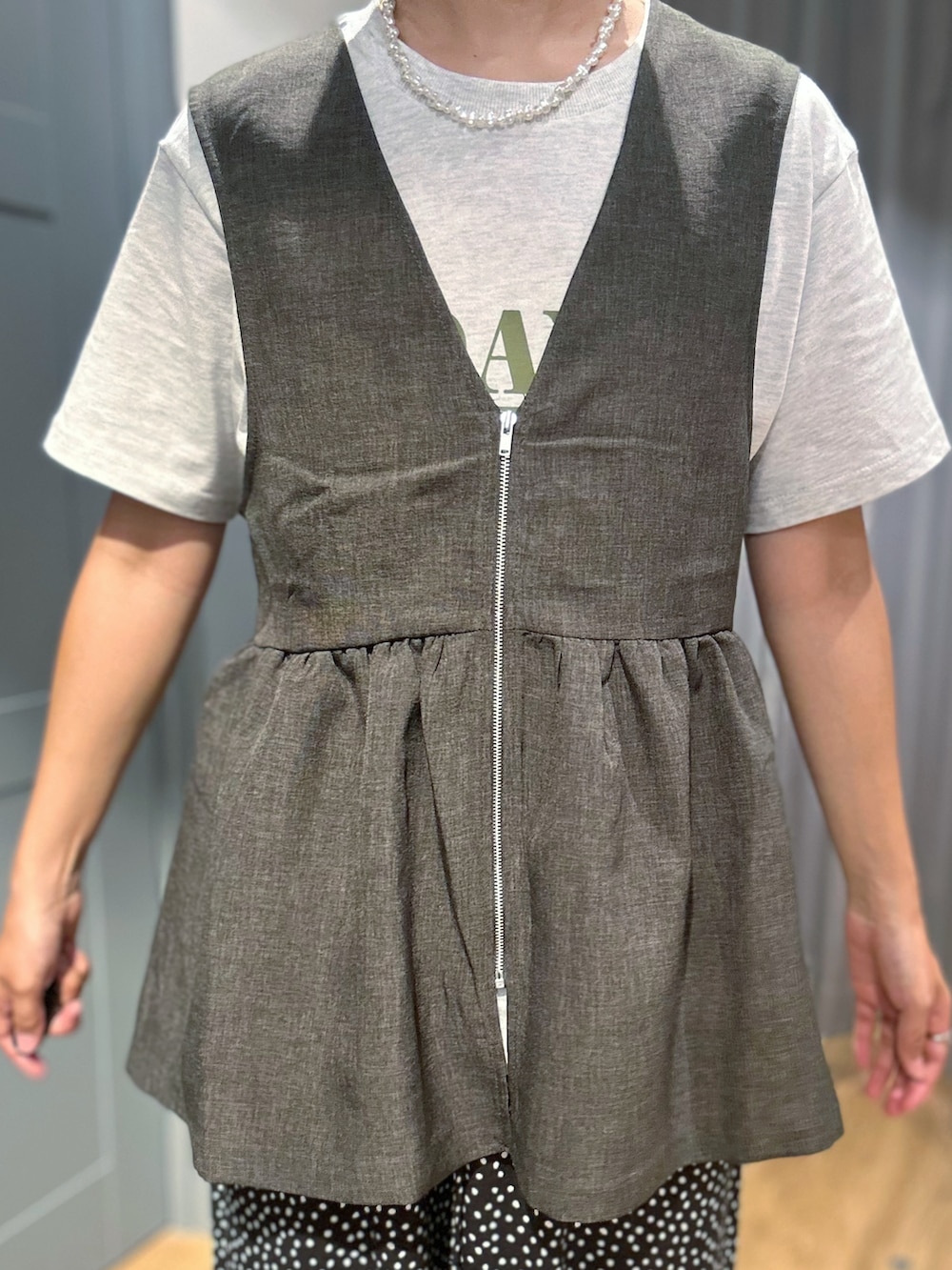 ホワイト系のその他パンツ、グレー系のベスト、ブラック系のショルダーバッグを着用したレディースの夏コーディネートの4枚目の写真