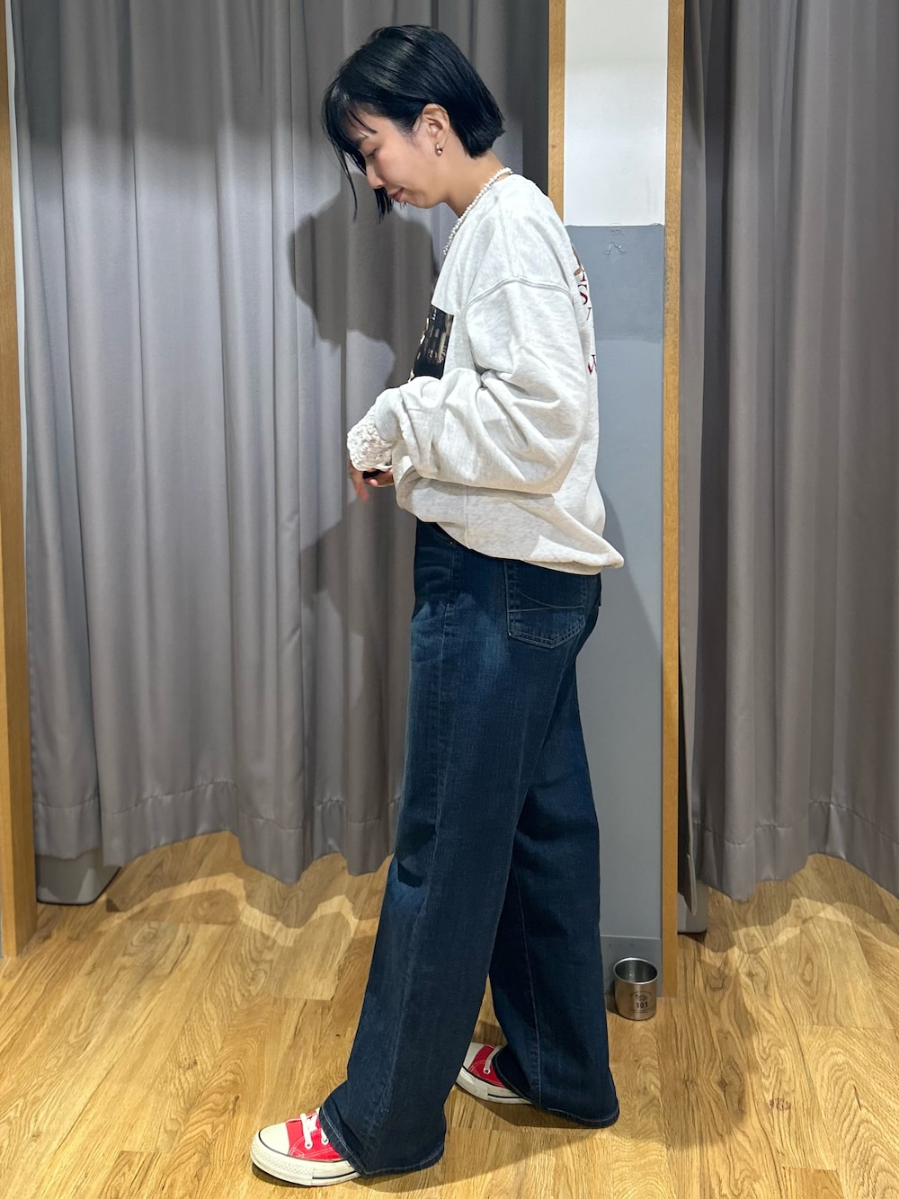 ベージュ系のスウェット、ホワイト系のTシャツ/カットソー、ブルー系のデニムパンツを着用したレディースの秋コーディネートの2枚目の写真