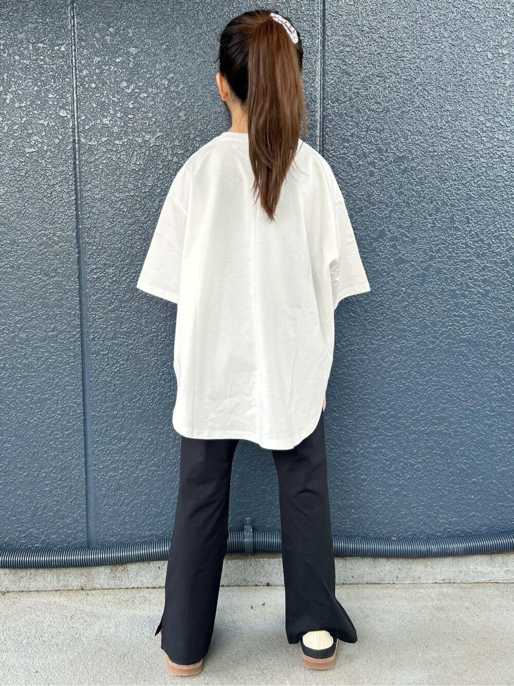 ホワイト系のTシャツ/カットソー、ブラック系のその他パンツ、シルバー系のショルダーバッグを着用したキッズの春コーディネートの4枚目の写真