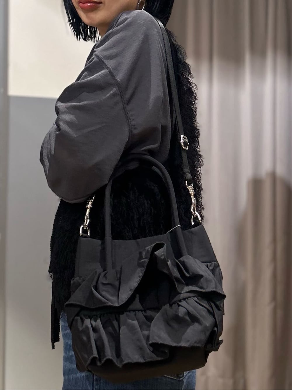 グレー系のTシャツ/カットソー、ブラック系のベスト、ブルー系のデニムパンツを着用したレディースの春コーディネートの9枚目の写真