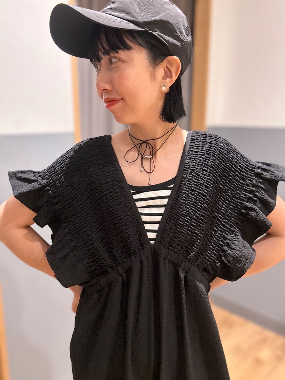 グレー系のショルダーバッグ、ブラック系のキャップを着用したレディースの夏コーディネートの4枚目の写真