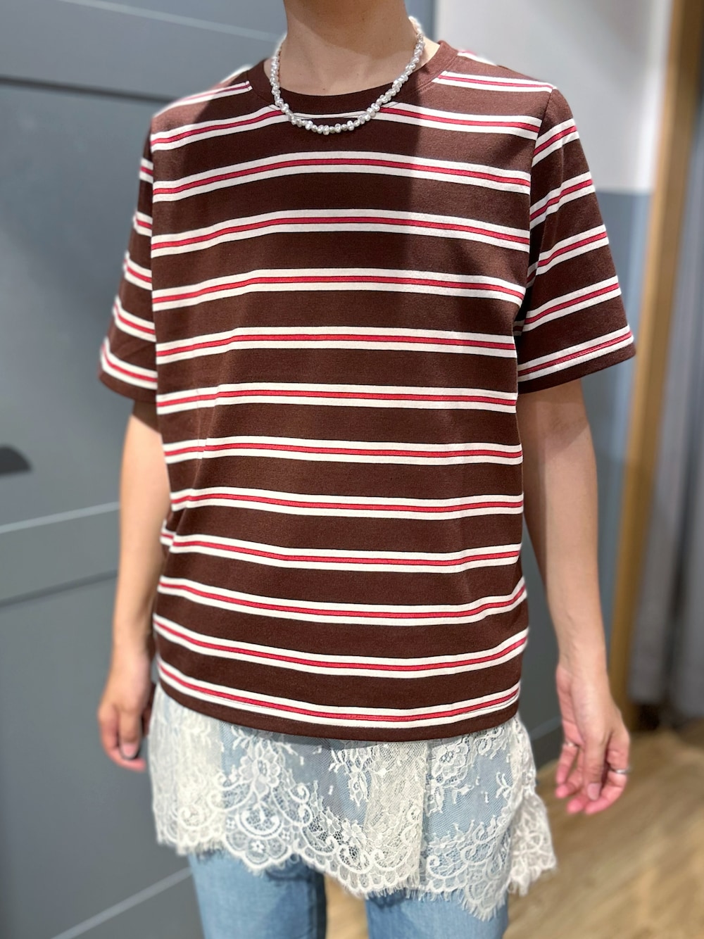 ブルー系のデニムパンツ、ブラック系のショルダーバッグ、ブラック系のキャップを着用したレディースの夏コーディネートの5枚目の写真