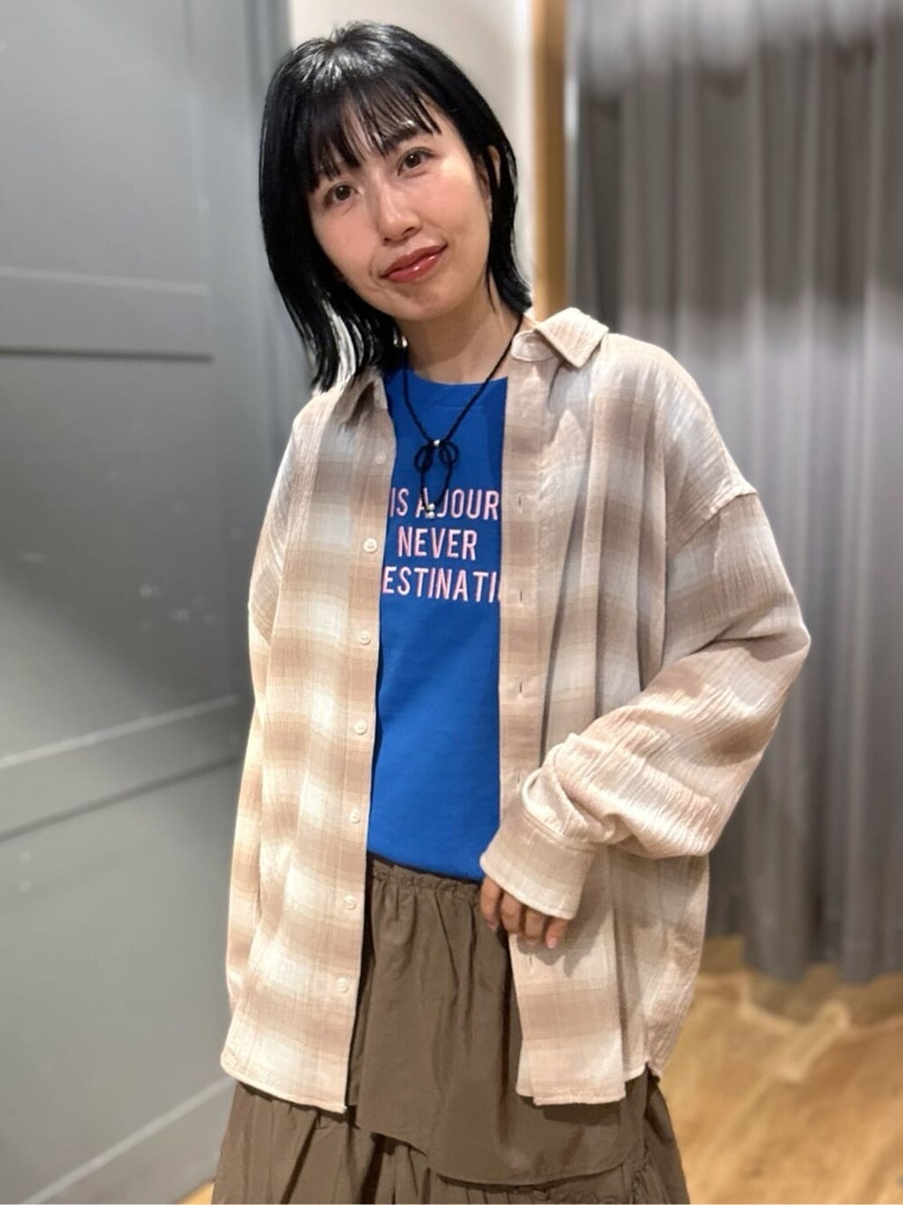 ブルー系のTシャツ/カットソー、ブラウン系のスカート、ベージュ系のシャツ/ブラウスを着用したレディースの春コーディネートの8枚目の写真
