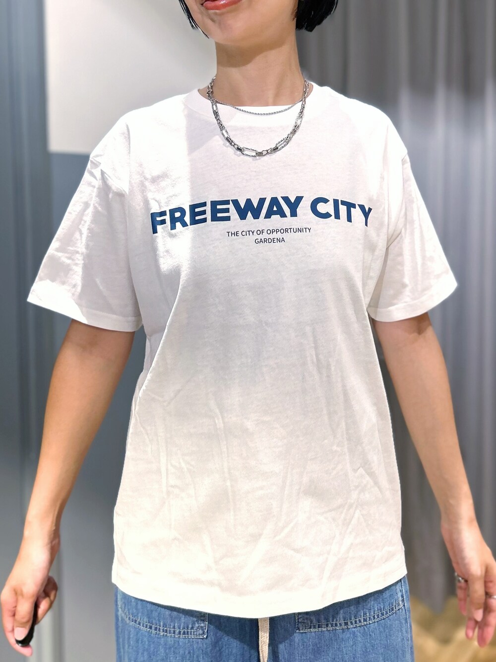 ホワイト系のTシャツ/カットソー、ブルー系のデニムパンツ、ブラック系のシャツ/ブラウスを着用したレディースの夏コーディネートの6枚目の写真