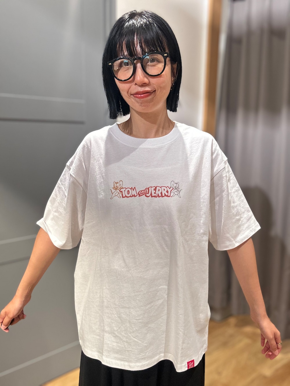ホワイト系のTシャツ/カットソー、ブラック系のスカート、ホワイト系のショルダーバッグを着用したレディースの夏コーディネートの4枚目の写真