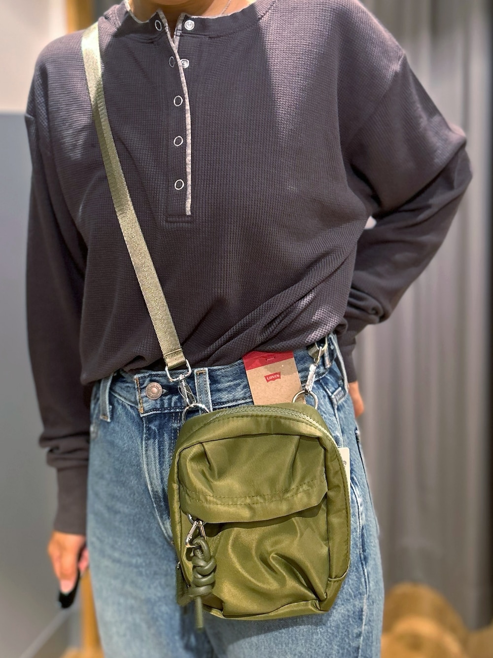 グレー系のTシャツ/カットソー、ブルー系のその他パンツ、グリーン系のショルダーバッグを着用したレディースの秋コーディネートの8枚目の写真