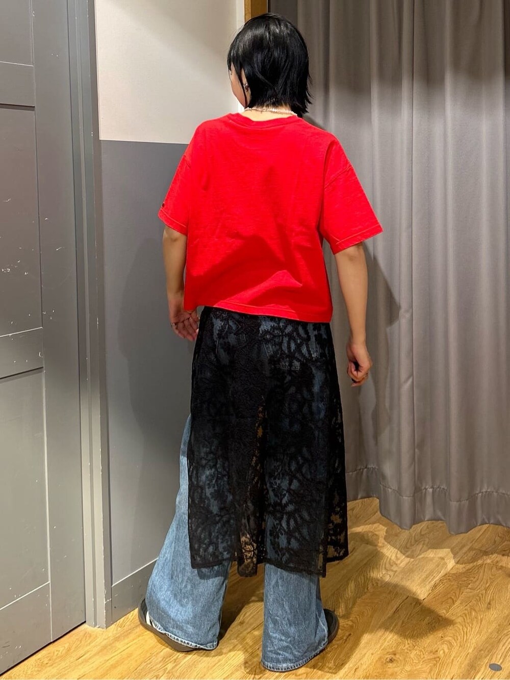 レッド系のTシャツ/カットソー、ブラック系のスカート、ブラック系のショルダーバッグを着用したレディースの春コーディネートの4枚目の写真
