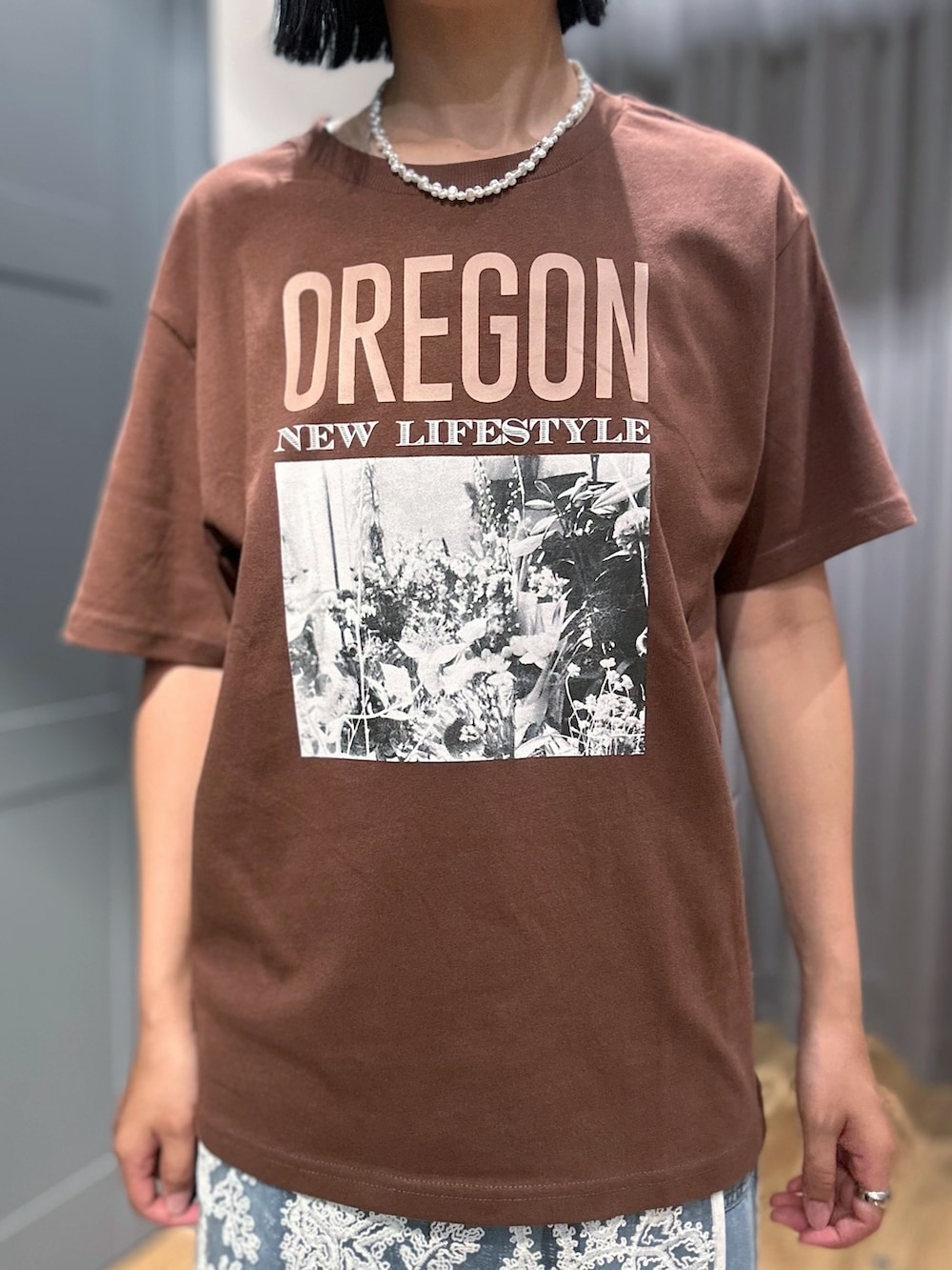 ブラウン系のTシャツ/カットソー、ブルー系のデニムパンツ、ホワイト系のスカートを着用したレディースの夏コーディネートの4枚目の写真
