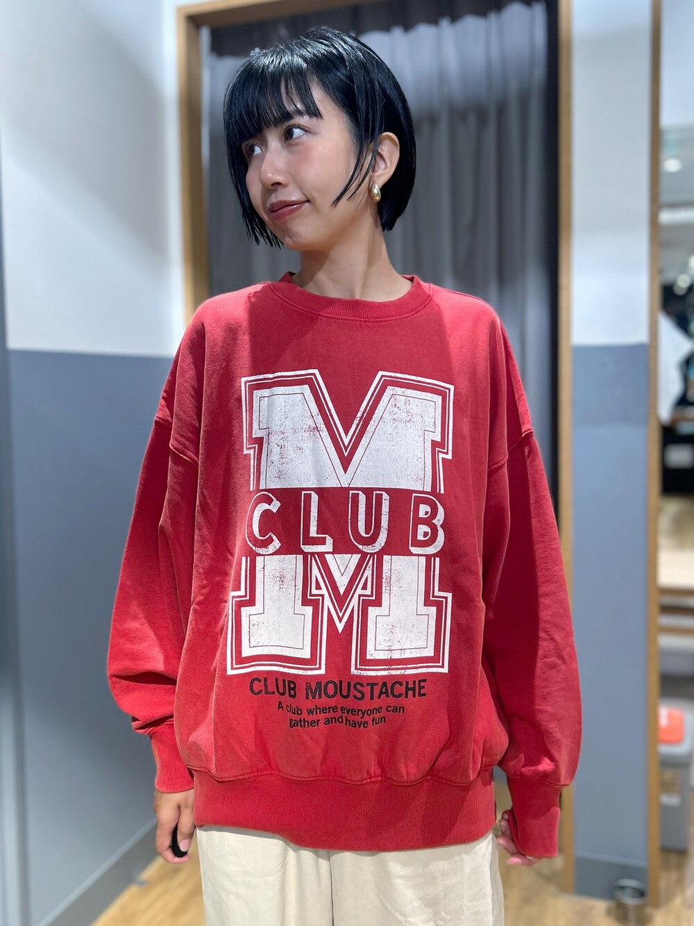 レッド系のスウェット、ホワイト系のその他パンツ、ブラウン系のバックパック/リュックを着用したレディースの秋コーディネートの4枚目の写真