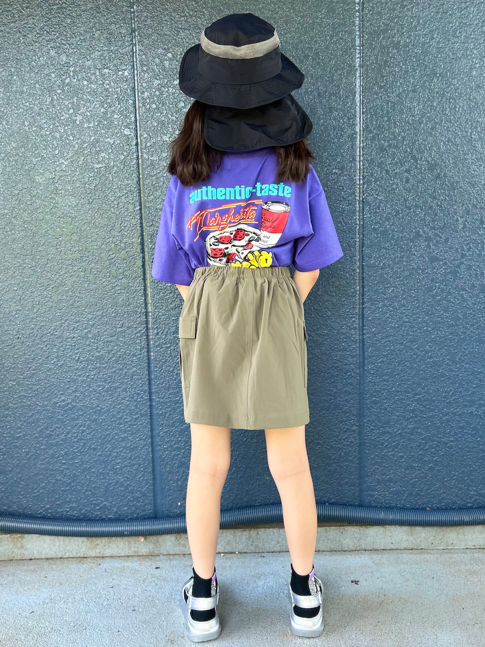 パープル系のTシャツ/カットソー、ブラウン系のスカート、ブラック系のハットを着用したキッズの春コーディネートの3枚目の写真