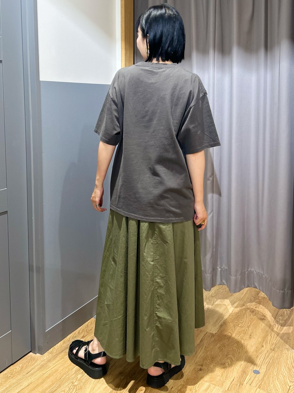 グレー系のTシャツ/カットソー、グリーン系のスカート、ブラック系のショルダーバッグを着用したレディースの夏コーディネートの3枚目の写真