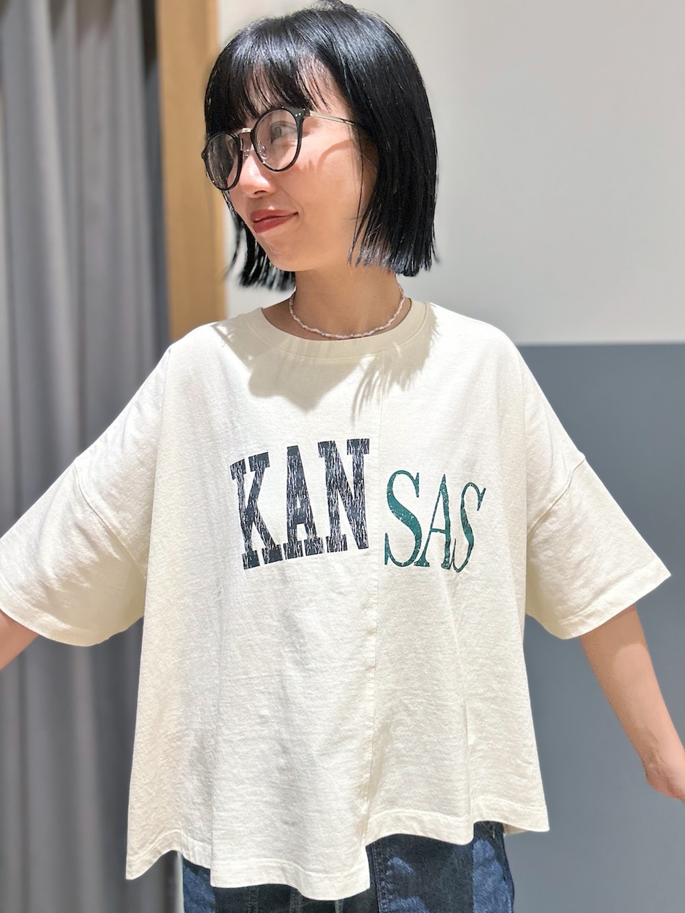 ホワイト系のTシャツ/カットソー、ブルー系のデニムパンツ、グリーン系のショルダーバッグを着用したレディースの夏コーディネートの4枚目の写真