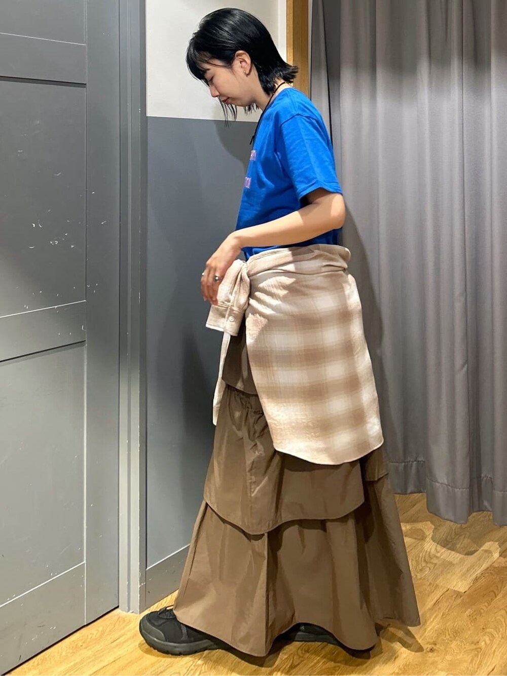 ブルー系のTシャツ/カットソー、ブラウン系のスカート、ベージュ系のシャツ/ブラウスを着用したレディースの春コーディネートの3枚目の写真