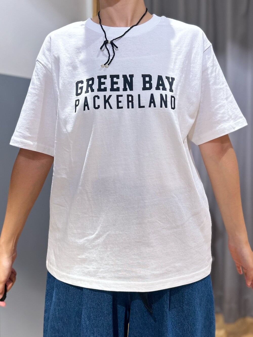 ホワイト系のTシャツ/カットソー、レッド系のベスト、ブルー系のその他パンツを着用したレディースの秋コーディネートの6枚目の写真