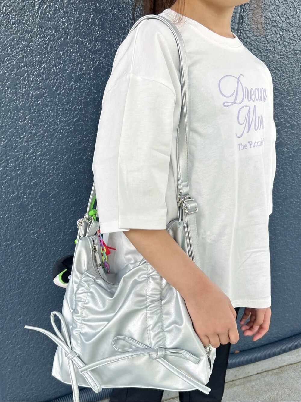 ホワイト系のTシャツ/カットソー、ブラック系のその他パンツ、シルバー系のショルダーバッグを着用したキッズの春コーディネートの9枚目の写真