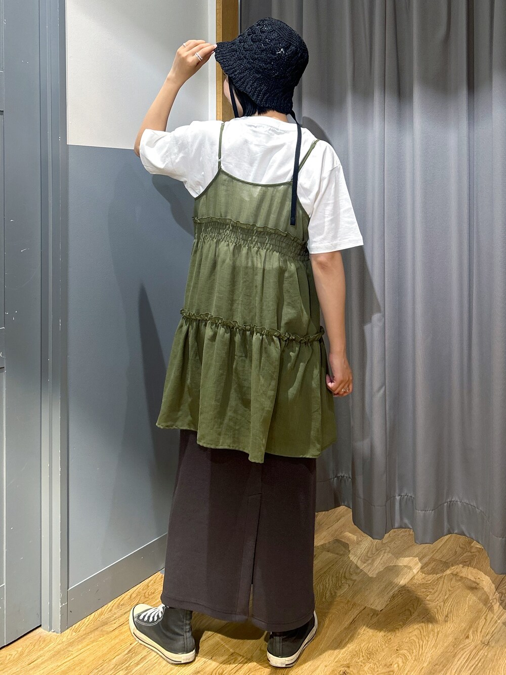 ホワイト系のTシャツ/カットソー、ブラウン系のベスト、ブラック系のハットを着用したレディースの春コーディネートの3枚目の写真