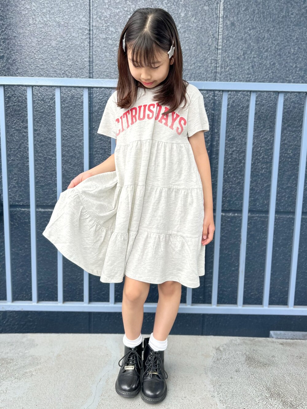 シルバー系のショルダーバッグ、ホワイト系のルームワンピースを着用したキッズの夏コーディネートの2枚目の写真