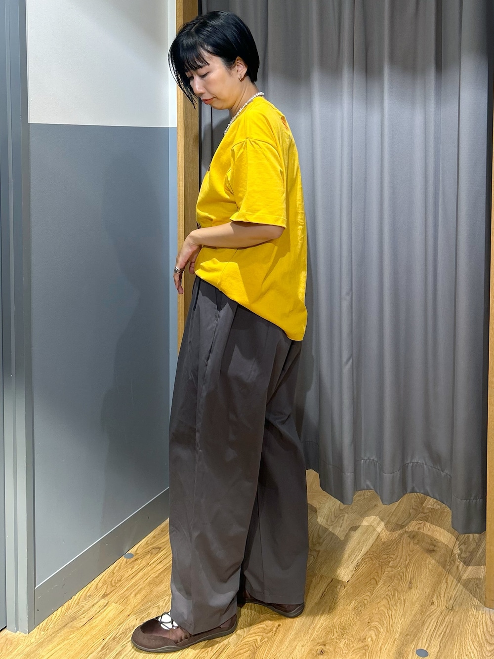 イエロー系のTシャツ/カットソー、グレー系のその他パンツ、ベージュ系のトートバッグを着用したレディースの夏コーディネートの2枚目の写真